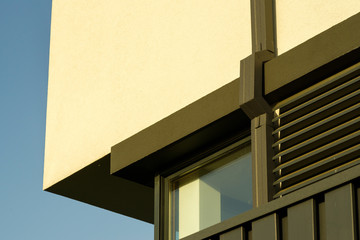 corner of the building., metal drainpipe on the wall near the window