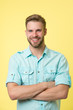 © be free - Cheerful consultant. Man smiling face posing confidently with folded arms yellow background. Man shop consultant looks cheerful confident and hospitable. Guy with bristle glad to help you in shop