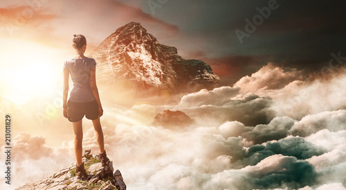 Fototapeta na szkło Hiker on peak with tall mountain in background