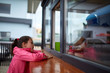 © Aleksey - Curious little girl waiting for her burger in the street shop window.