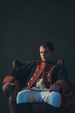 Man In Empire Style Sitting In Chair.