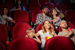 © fotofabrika - Group of friends sitting in movie theater with popcorn and drinks