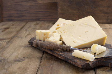 A beautiful Swiss cheese with holes, a useful dairy product. Tasty food. Country style photo. Place for text. Copy space.