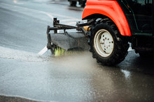 Cleaning Sweeper Machines Washes The City Asphalt Road With Water Spray.