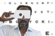 © JPC-PROD - middle aged afro-american man getting eye exam at ophthalmologit bright office letter chart background