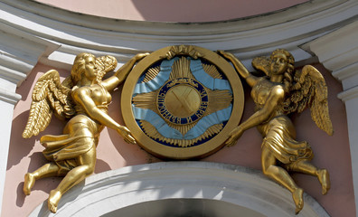 Wall Mural - Sculptures of angels holding a sign of St Andrew The Apostle with words For faith and Loyalty above the entrance of St.Andrew Cathedral, Saint Petersburg, Russia