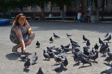 
A Woman Is Feeding Pigeons.
