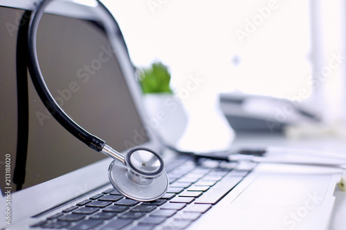 Fotomural Stethoscope lying on a laptop keyboard in a concept of online medicine or troubl