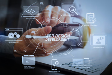 close up of businessman working with mobile phone and stylus pen and laptop computer on wooden desk in modern office