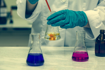 Chemical laboratory. The lab assistant's hands mix the solution in a test tube, doping test, toned