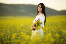 Pretty Woman With Bouquet Of Wildflowers In Yellow Field In Sunset Lights, Summer Time
