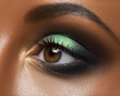 Macro and close-up creative make-up theme: beautiful female eye with green and golden shadows, black skin