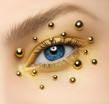 Macro And Close-up Creative Make-up Theme: Beautiful Female Eye With Golden Eye Shadows And Golden Balls