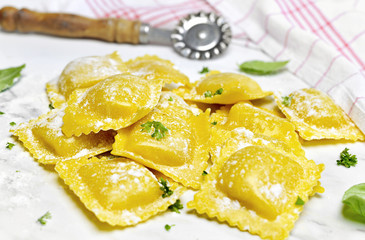 Wall Mural - Ravioli pasta, homemade pasta and pasta roller on a stone background. Italian cuisine, fresh pasta cooking.