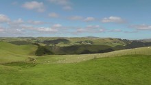 Wide Shot - Welsh Countryside With Grazing Sheep, A Waterfall And Wind Turbines