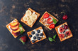 Belgian waffles with blueberries,strawberries,peaches, cherries and banana. Homemade waffles on a dark rustic background. The view from the top,flat lay.