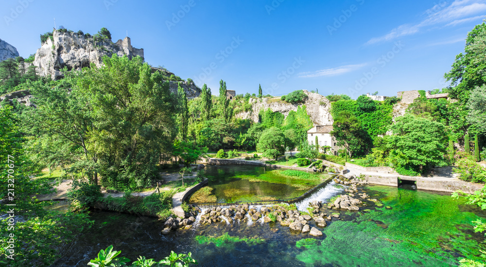 The river Sorgue in Fontaine de Vaucluse in the background the castle ruins from Philp Cabassole. Vaucluse, Provence, France, Europe - obrazy, fototapety, plakaty 