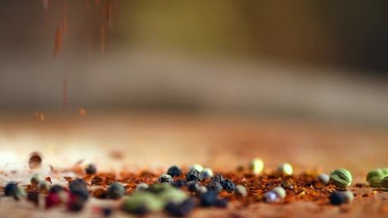 Wall Mural - Spices falling from wooden spoon. Pepper, paprika, seasonings closeup. Cooking. Various Indian spices and herbs on wooden table. Slow motion. 3840X2160 4K UHD video footage