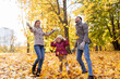 © Syda Productions - family, season and people concept - happy mother, father and little daughter playing with autumn leaves at park