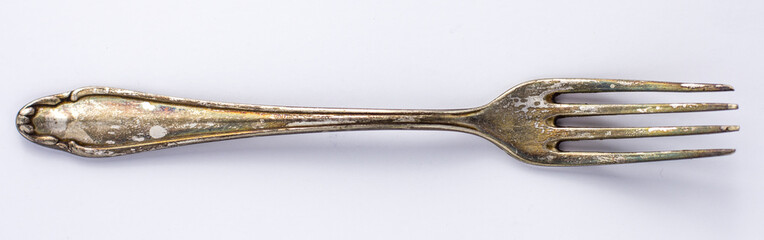 Very old rusty vintage silver fork isolated on a white background, close up, top view