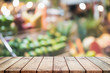 Wood table top on blurred with bokeh fruit in supper market background - can be used for display or montage your products.