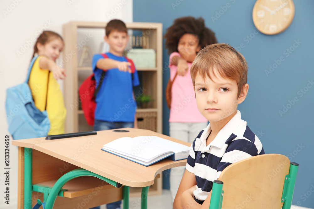 Children bullying little boy in classroom