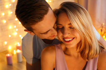 Wall Mural - Young loving couple against blurred lights background