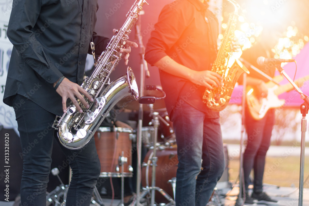 World Jazz festival. Saxophone, music instrument played by saxophonist player and band musicians on stage in fest. - obrazy, fototapety, plakaty 