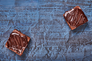 Wall Mural - homemade chocolate brownies on dark blue background, top view