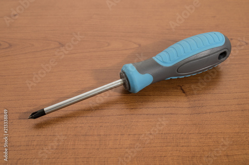 Fotografie, Obraz Tools, blue screwdriver on a walnut table