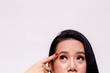 © twinsterphoto - Asian young woman worried and pointing finger towards her aging and old forehead - with copy space - treatment skin care concept.