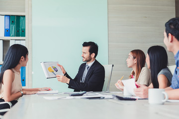 Manager holding papers hands and Smiling Professional team of coworlcers making great business discussion in modern office teamwork people.