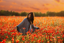 Woman Relaxing In Poppy Meadow.