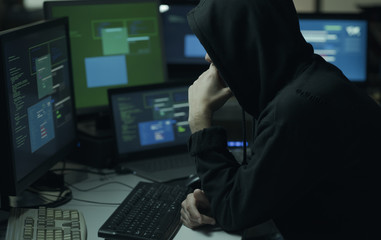 hacker with hoodie working with a computer