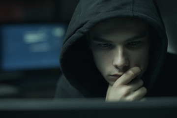 cool hacker with hoodie working with computers