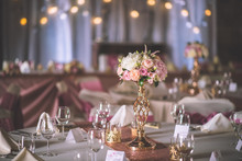 Wedding Table With Exclusive Floral Arrangement Prepared For Reception, Wedding Or Event Centerpiece In Rose Gold Colour
