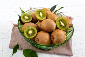 Wall Mural - Ripe kiwi fruit in a bowl on a white wooden background.