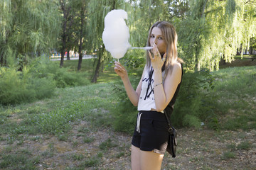 Wall Mural - Girl eating Сotton Сandy in the park