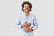 © wayhome.studio  - Positive mixed race male touches stomach, can`t stop laughing, being in good mood, hears funny stories from interlocutor, expresses happiness, dressed elegantly, isolated on white background