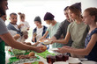 © New Africa - Volunteers serving food for poor people indoors