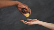 Man giving golden Bitcoin to woman hand