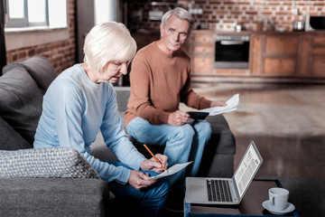 Wall Mural - Lets work. Attentive female person sitting in semi position while making notes