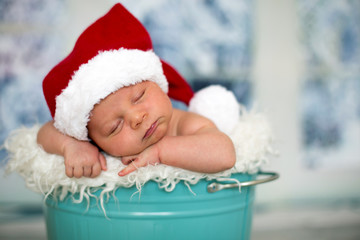 Portrait of a newborn baby boy,l wearing christmas hat, sleeping