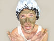 © TheVisualsYouNeed - weird looking man with shower cap and cream on his face horrified seeing himself ugly on bathroom mirror applying facial mask male cosmetics