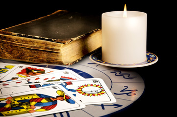 Wall Mural - tarot tarots cards with magic book and candle on astrology wheel like esoteric concept 