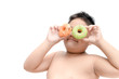 © kwanchaichaiudom - Obese fat boy is eating donut isolated