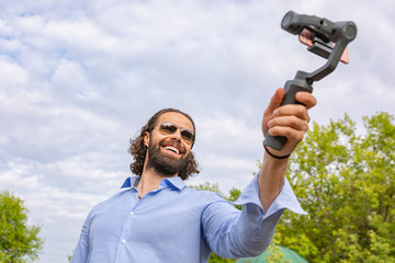 guy with the phone on the stabilizer, He takes himself to the camera Smartphone Camera