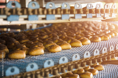 Cuadros en Lienzo Cakes on automatic conveyor belt or line, process of baking in confectionery culinary factory or plant