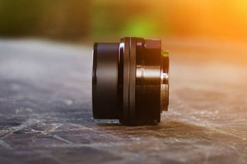 Lens for camera, on an old wooden desk, black lens, photographer