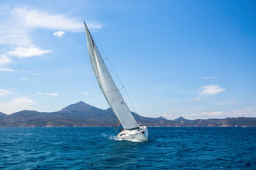 Luxury sailing yacht in the wind through the waves at the Aegean Sea.